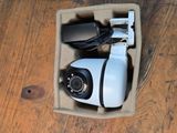 a small camera in a box on a wooden floor