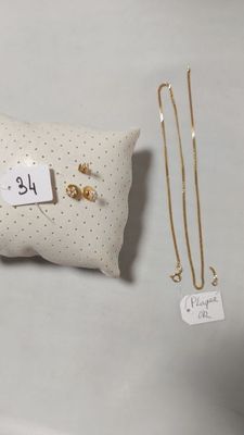 un oreiller muni d'une étiquette, à côté d'une paire de boucles d'oreilles
