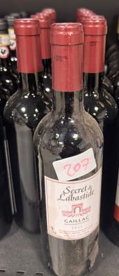 plusieurs bouteilles de vin sont alignées sur une étagère dans un magasin