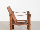 a brown leather chair sitting on top of a cement floor