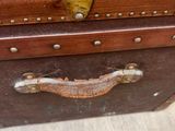 a brown suitcase sitting on top of a wooden floor