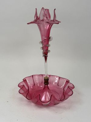 pink glass candle holder with a glass flower on top of it