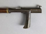 an old gun with a wooden handle on a white surface