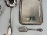 a lot of silver spoons and other silverware on a table