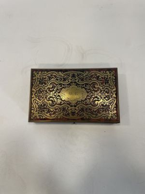 an old brass cigarette case sitting on top of a white table