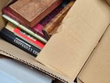 a cardboard box full of books on the floor
