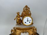 a gold clock sitting on top of a marble base