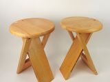 two small wooden stools sitting next to each other on a white surface