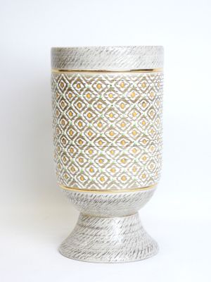 a white vase with a pattern on it on a table