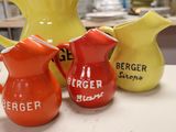three pitchers sitting on a table next to each other