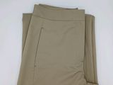 un gros plan sur un pantalon beige posé sur une surface blanche