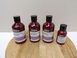 three bottles of liquid sitting on top of a wooden cutting board