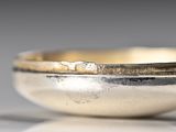 a close up of a silver bowl on a table
