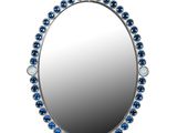 miroir orné de perles de verre bleues et d'un cadre argenté sur fond blanc