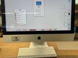 a computer monitor sitting on a desk with a keyboard and mouse