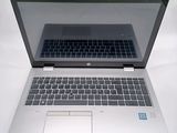 a silver laptop with a black keyboard on a white surface