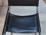 une chaise noire qui se trouve au milieu d'une pièce