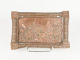 carvings on a metal tray on a stand on a white surface