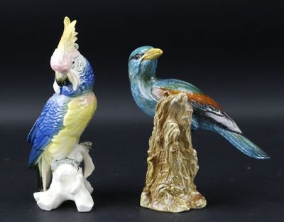 deux figurines d'oiseaux perchés sur une souche d'arbre