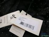two tags are attached to a black jacket with a barcode on it