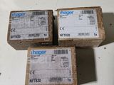 Trois boîtes de Hager sont empilées les unes sur les autres sur une table.