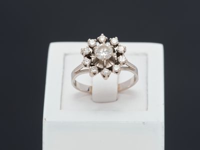 un gros plan d'une bague en diamant posée sur une boîte blanche