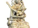 statue en laiton représentant une femme assise sur un rocher, tenant une harpe