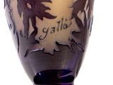 a purple vase with a design of leaves on it