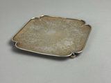 assiette rectangulaire en argent, ornée d'un motif floral sur fond blanc