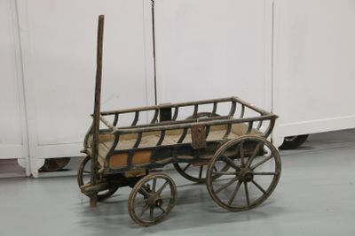 a small wooden wagon with a wooden seat on the floor