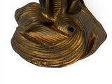 a gold statue of a bird on top of a rock