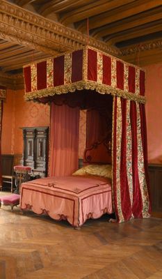 une photo d'une chambre à coucher avec un lit à baldaquin