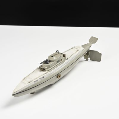 un bateau miniature posé sur une surface blanche