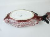 a fish shaped bowl on a table with a spoon in it