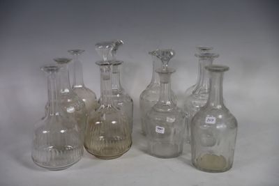 six clear glass bottles are lined up on a white surface