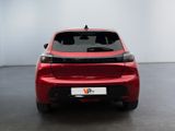 the rear end of a red car in a room with a white wall
