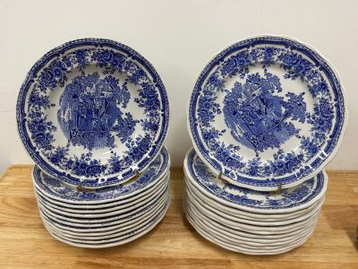 several blue and white plates stacked on top of each other on a wooden table