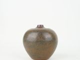 a small brown vase sitting on a white surface