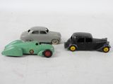 three toy cars sitting next to each other on a white surface