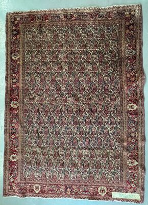 tapis persan ancien avec un motif floral sur fond bleu