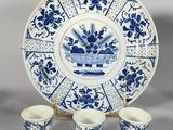 a blue and white plate and cups on a stand