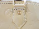 a close up of a white purse with a gold buckle