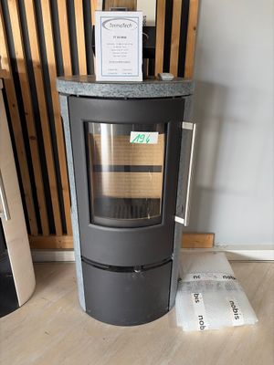 a black stove sitting in a room next to a wall