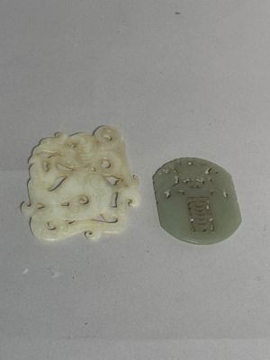 two pieces of white and green clay on a white surface
