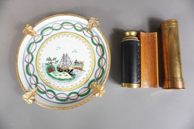 une assiette sur laquelle est représenté un bateau, à côté d'une paire de jumelles