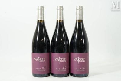 trois bouteilles de vin posées sur une table blanche