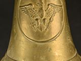 an old brass bell with a bird on it on a black background