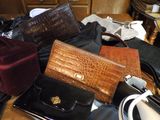 a pile of purses sitting on a table next to other purses