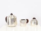 three silver teapots sitting on a white table