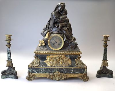 une statue représentant une femme assise au sommet d'une horloge, à côté de trois bougies